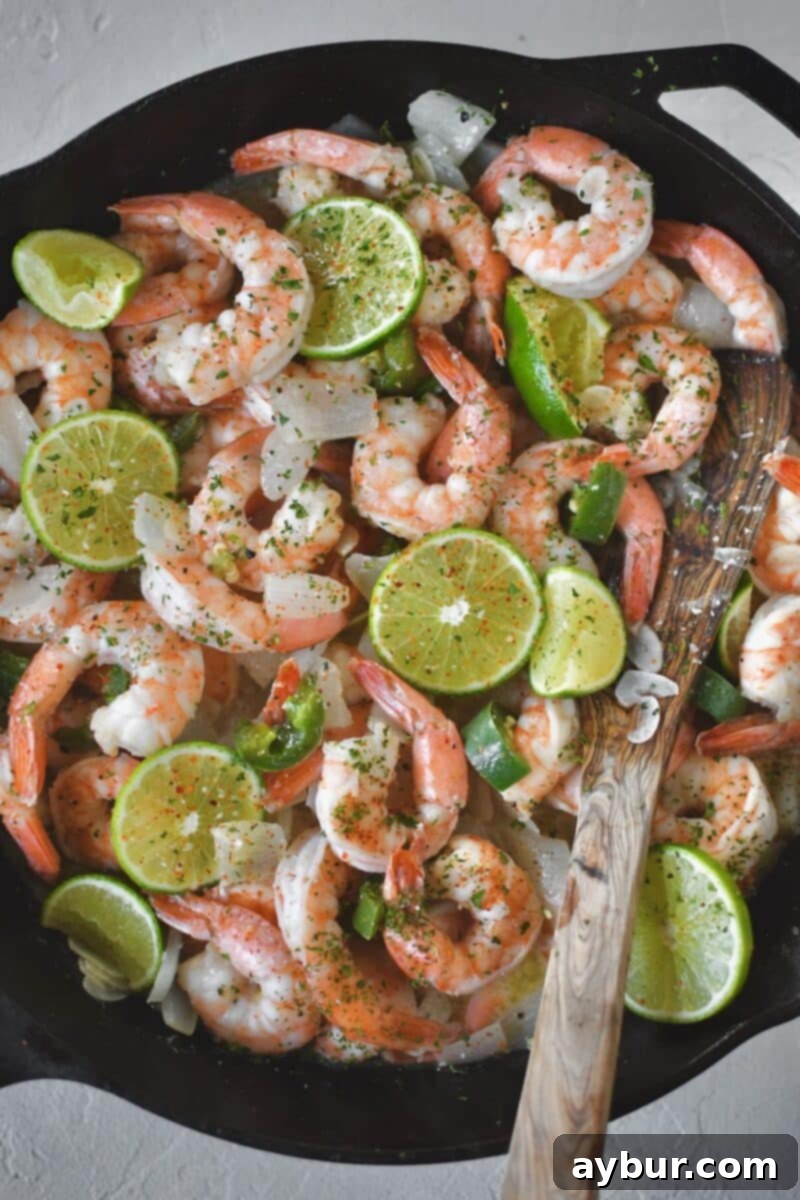 Step three: Perfectly cooked pink shrimp, with optional lime, cilantro, and Tajin seasoning added for extra flavor.