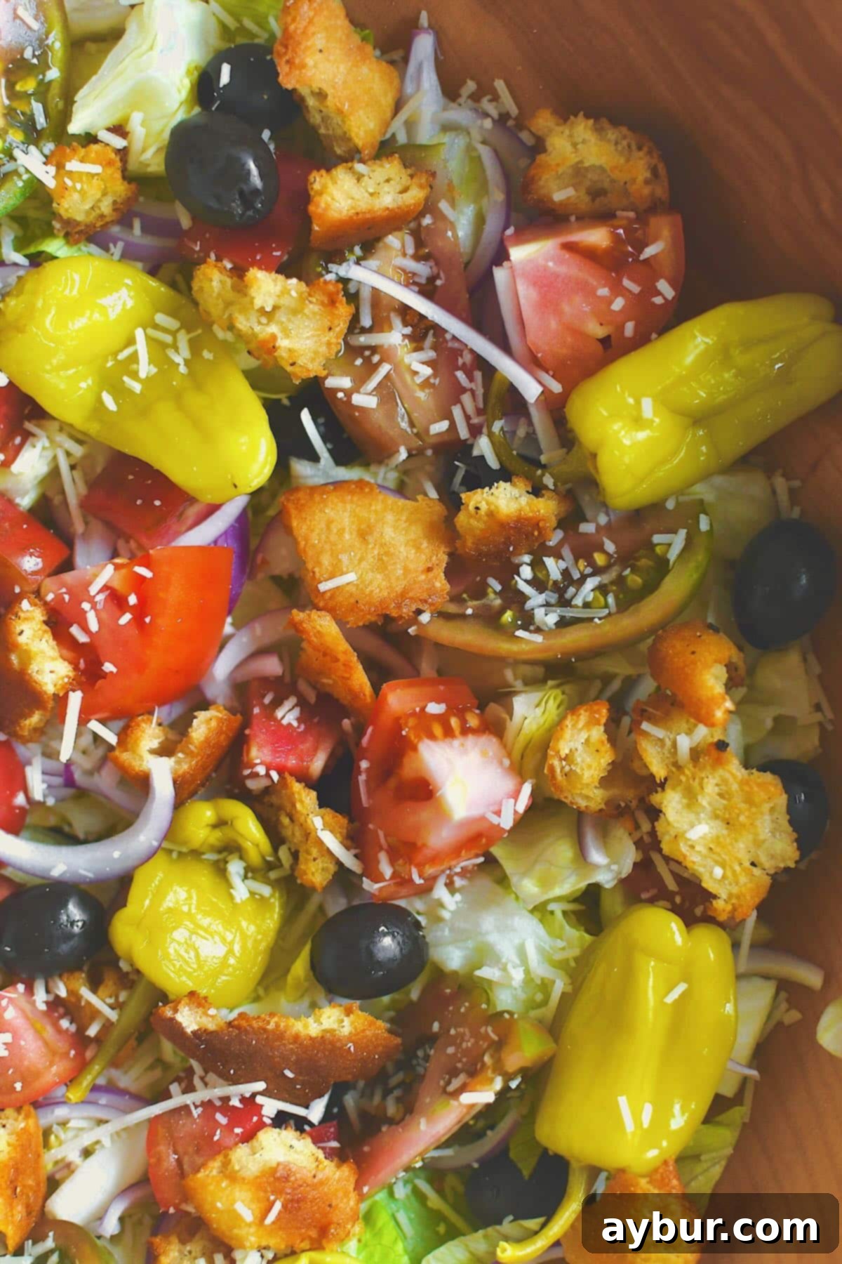 Olive Garden Italian Salad beautifully topped with all ingredients, just before the final mix.