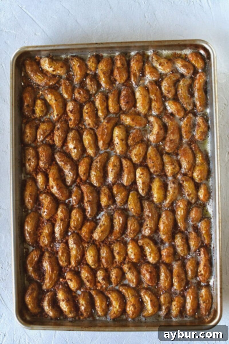 Seasoned potatoes, placed cut side down on a buttered sheet pan that has been dusted with parmesan cheese that have crisped during baking.