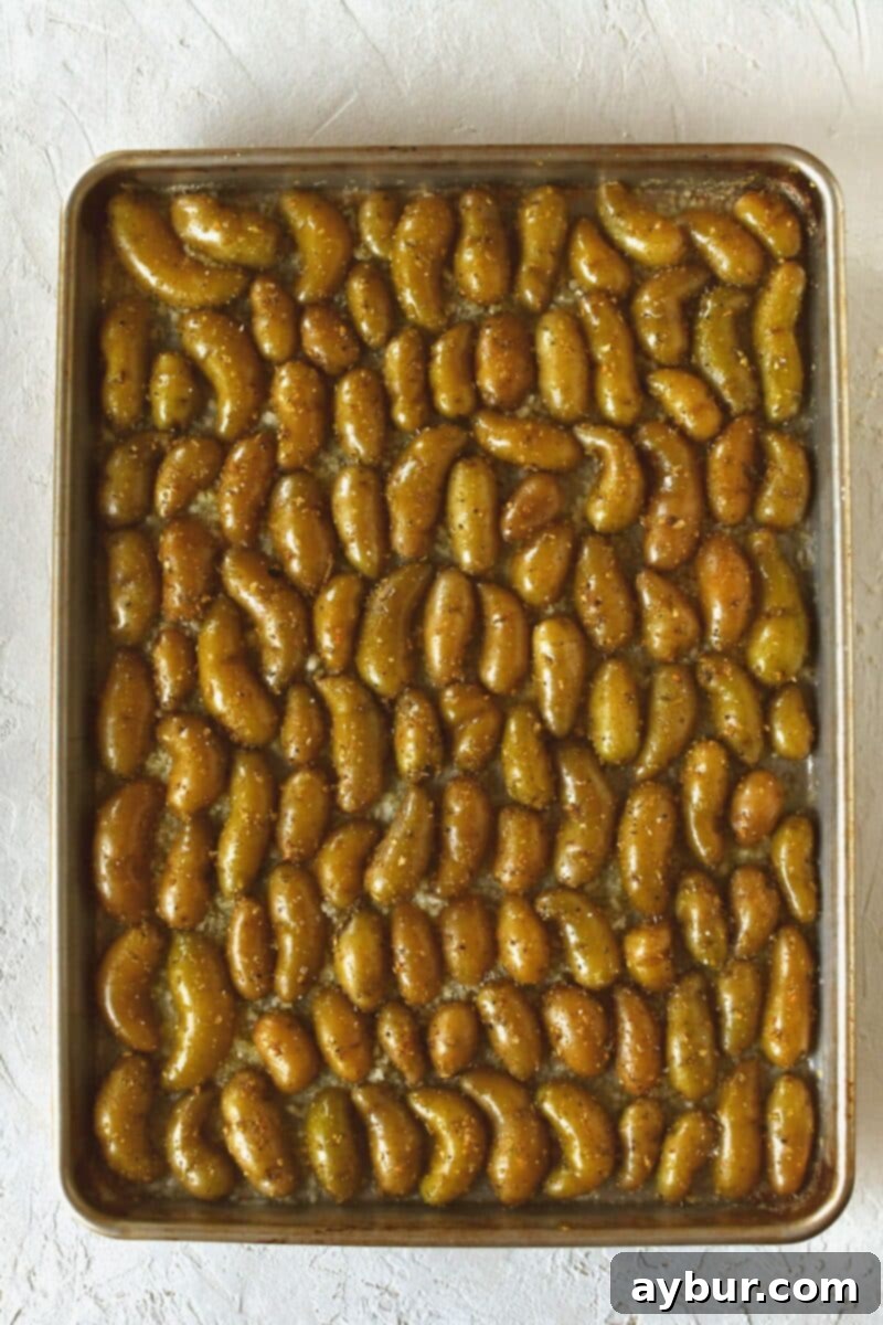 Seasoned potatoes, placed cut side down on a buttered sheet pan that has been dusted with parmesan cheese that will crisp when baked.