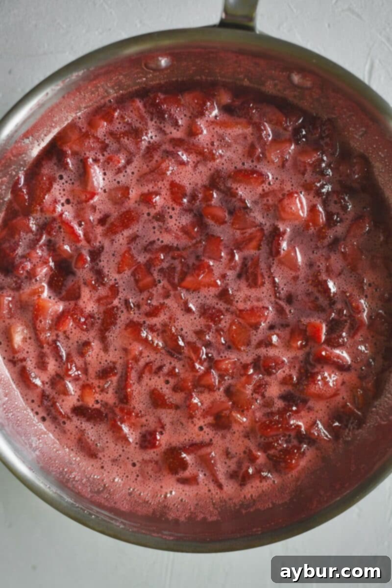 Diced strawberries and sugar in a saute pan after cooking.