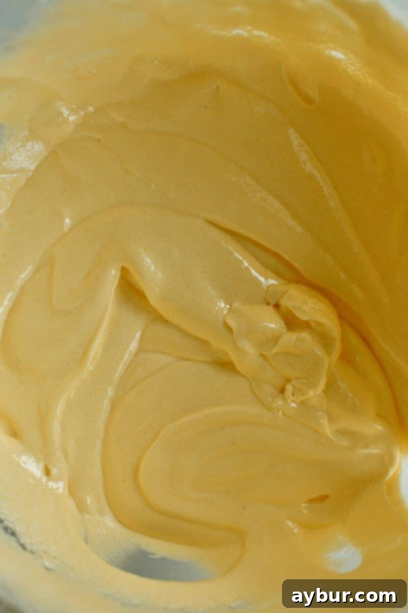 Stage 3 of making the cake, eggs and yolks added to the fluffed fats and sugar.