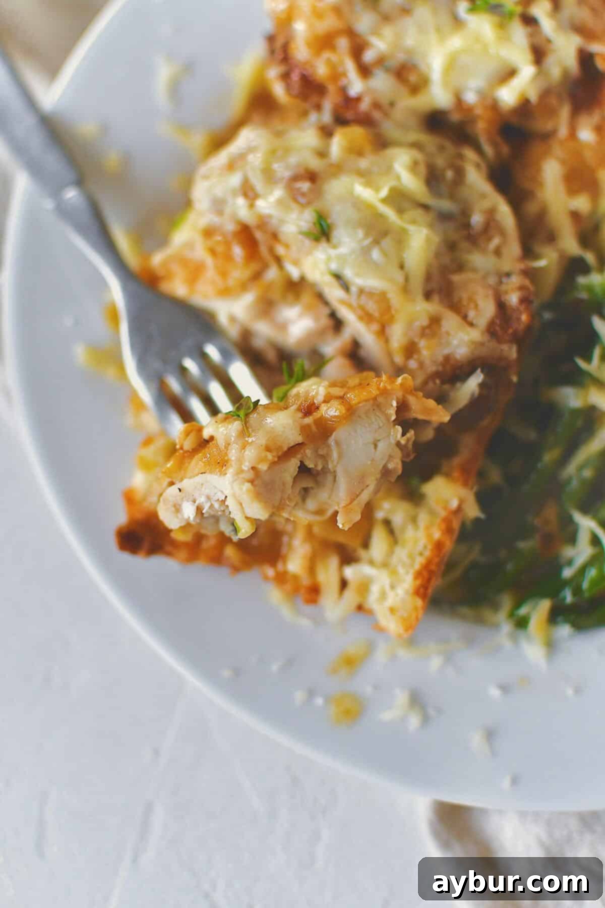 French Onion Chicken served over a piece of crusty bread to soak up the extra sauce and some sauteed green beans.