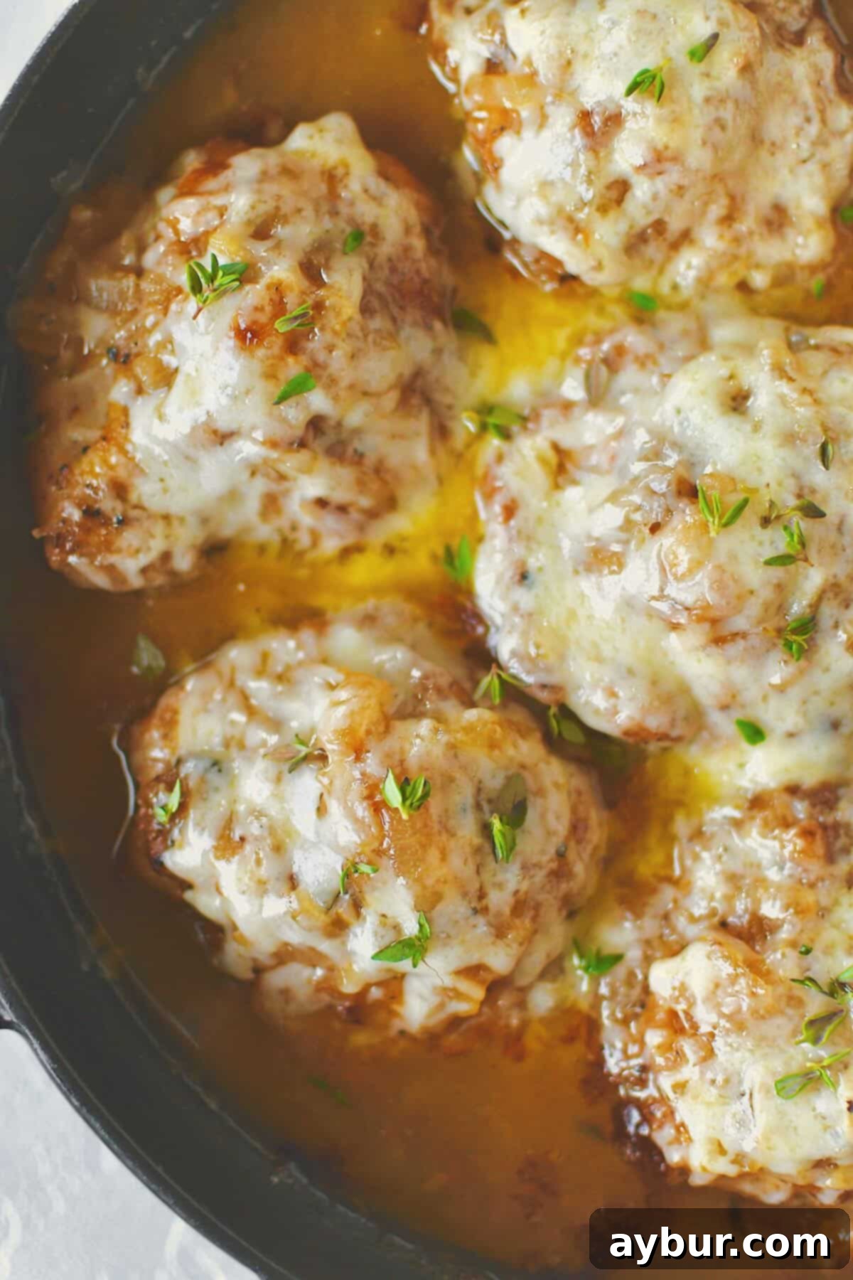 French Onion Chicken ready to eat, covered in golden, melty cheese and surrounded by rich onion sauce.