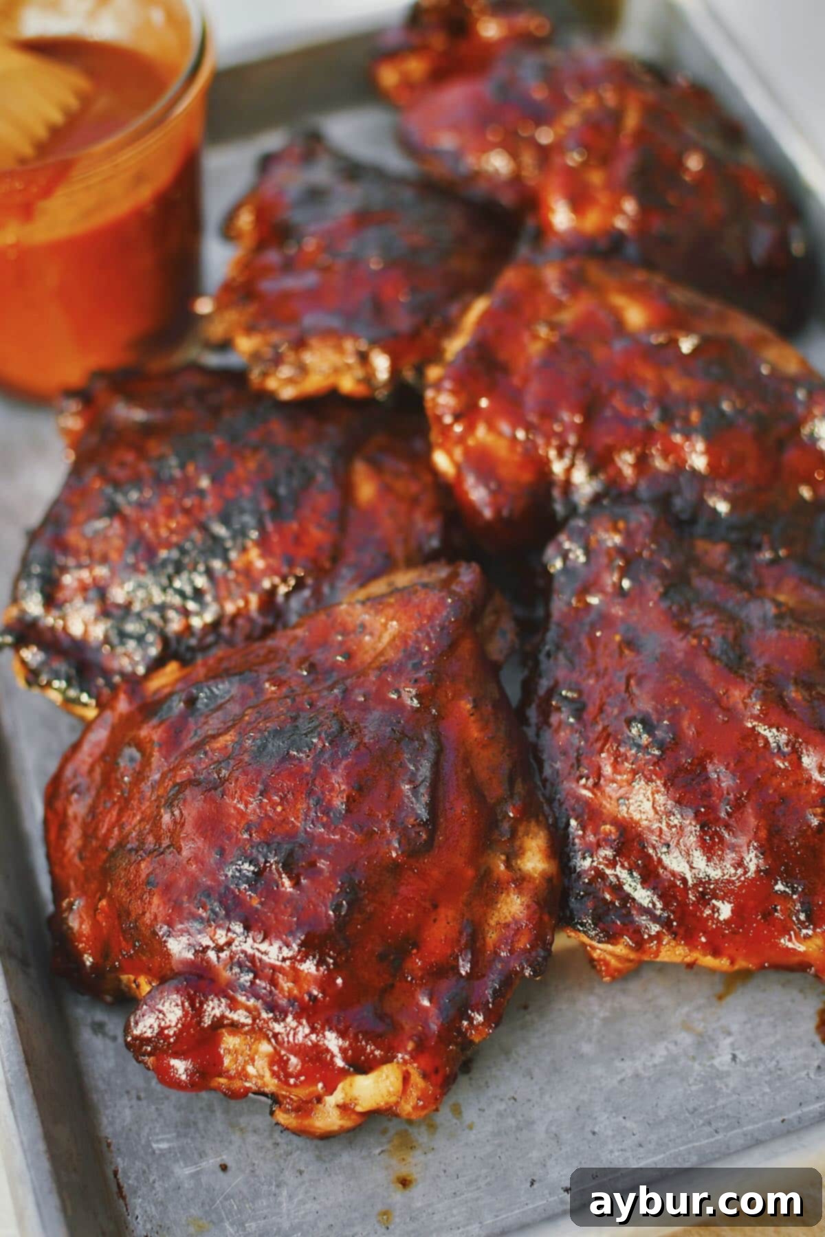 Ultimate Grilled Chicken Thighs 2 Grilled Chicken Thighs fresh off the grill and slathered in bbq sauce.