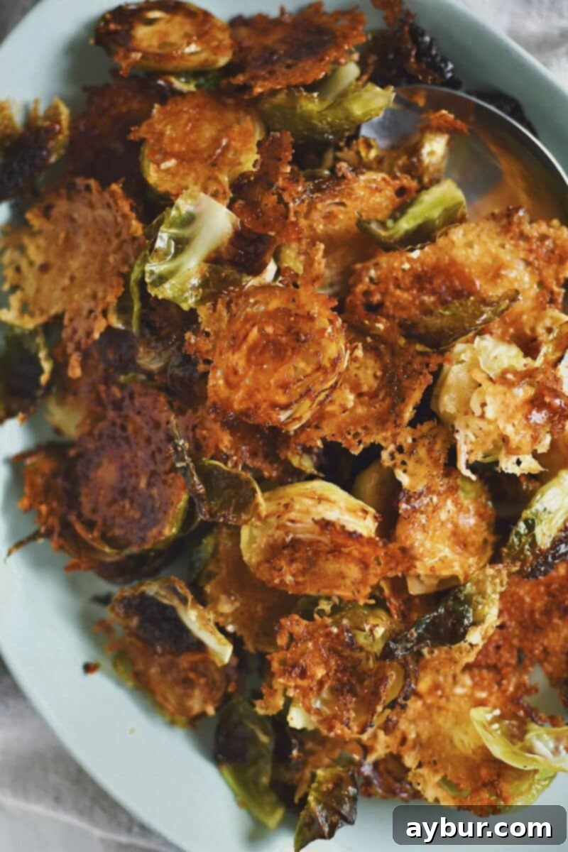 A close-up view of perfectly cooked Parmesan Brussels sprouts on a plate, showcasing their crispy edges and delicious cheese crust, ready to be enjoyed.