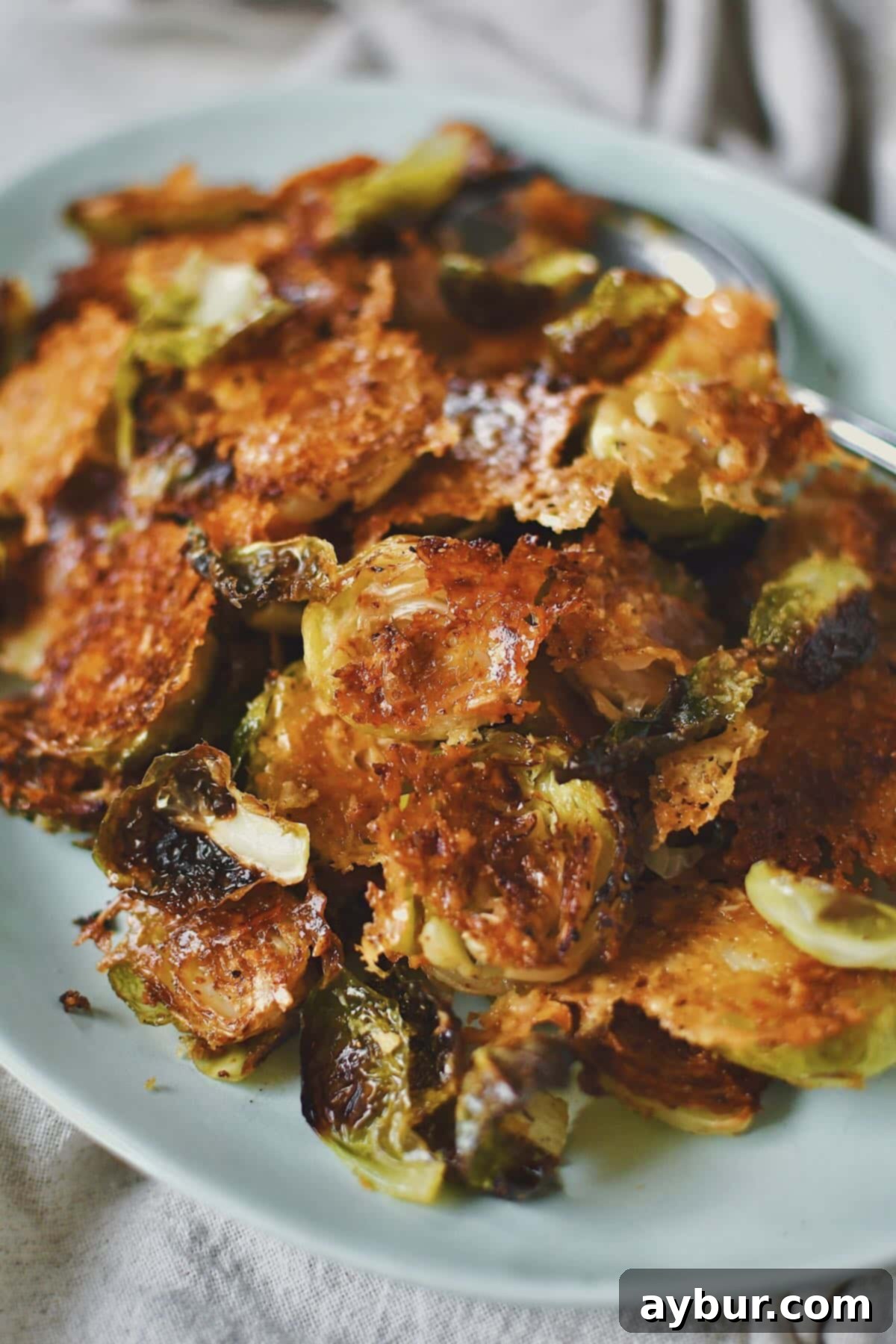 A vibrant, well-lit shot of crispy Parmesan Brussels sprouts, freshly prepared and garnished with fresh herbs, ready to be served.