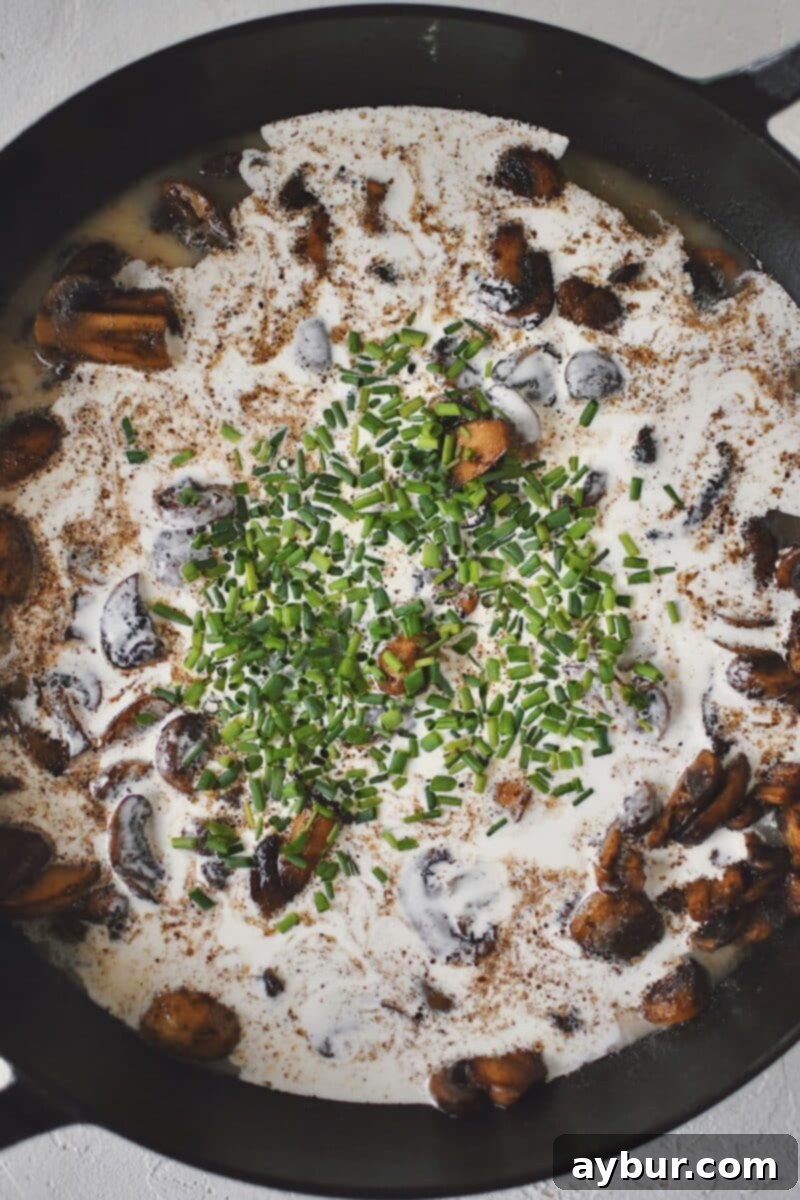 Velvety Mushroom Chicken 8 Pouring chicken stock and heavy cream into the skillet with cooked mushrooms and garlic to form the creamy sauce.