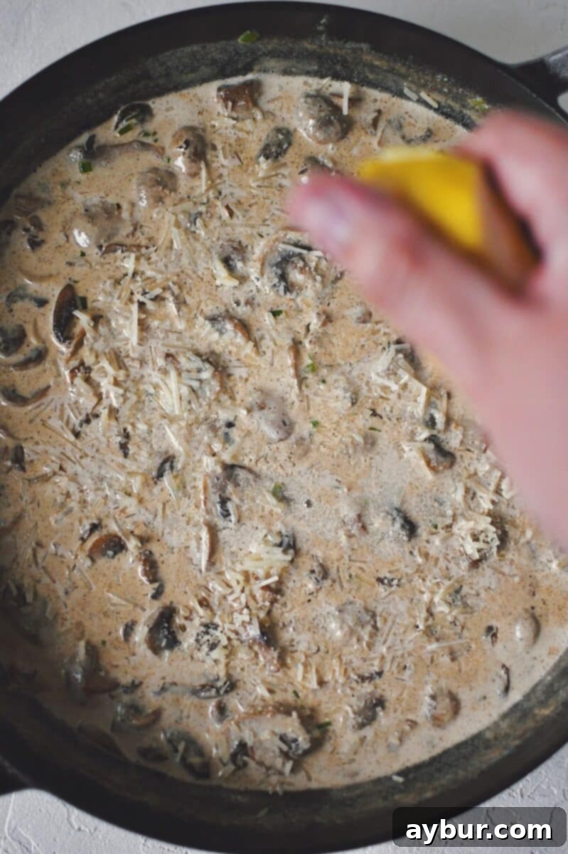 Velvety Mushroom Chicken 10 Adding grated Parmesan cheese and a squeeze of fresh lemon juice to the simmering creamy mushroom sauce for the finishing touch.