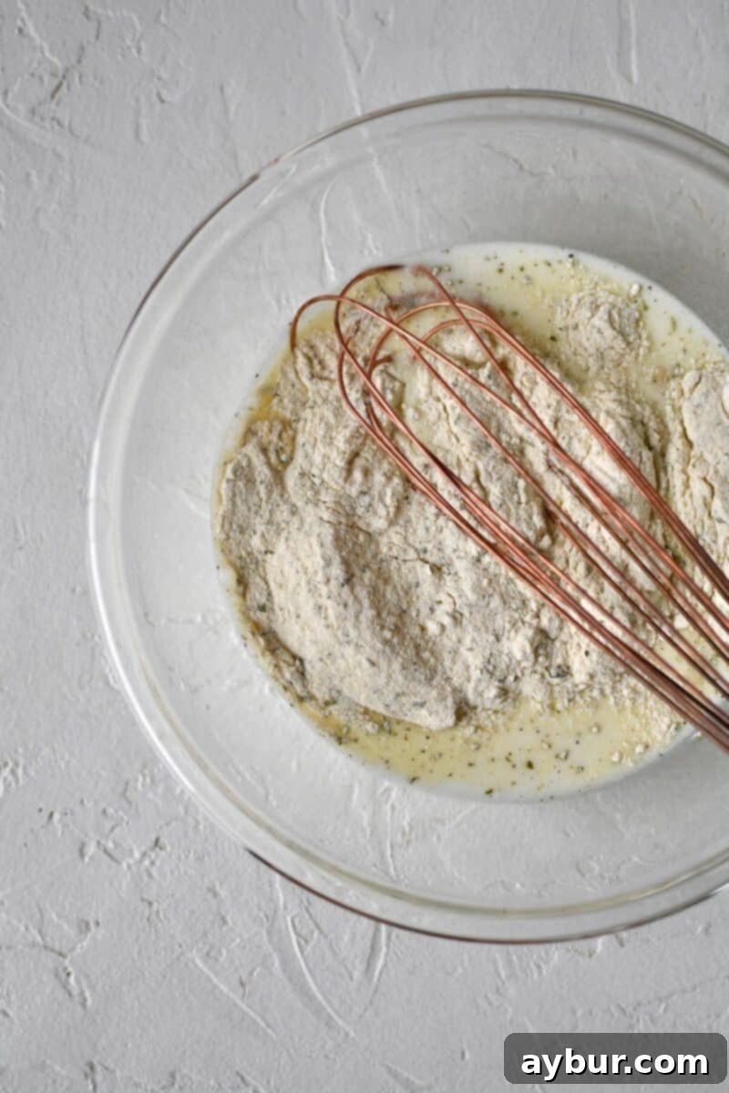 Making homemade ranch: milk and ranch powder being whisked in a bowl.