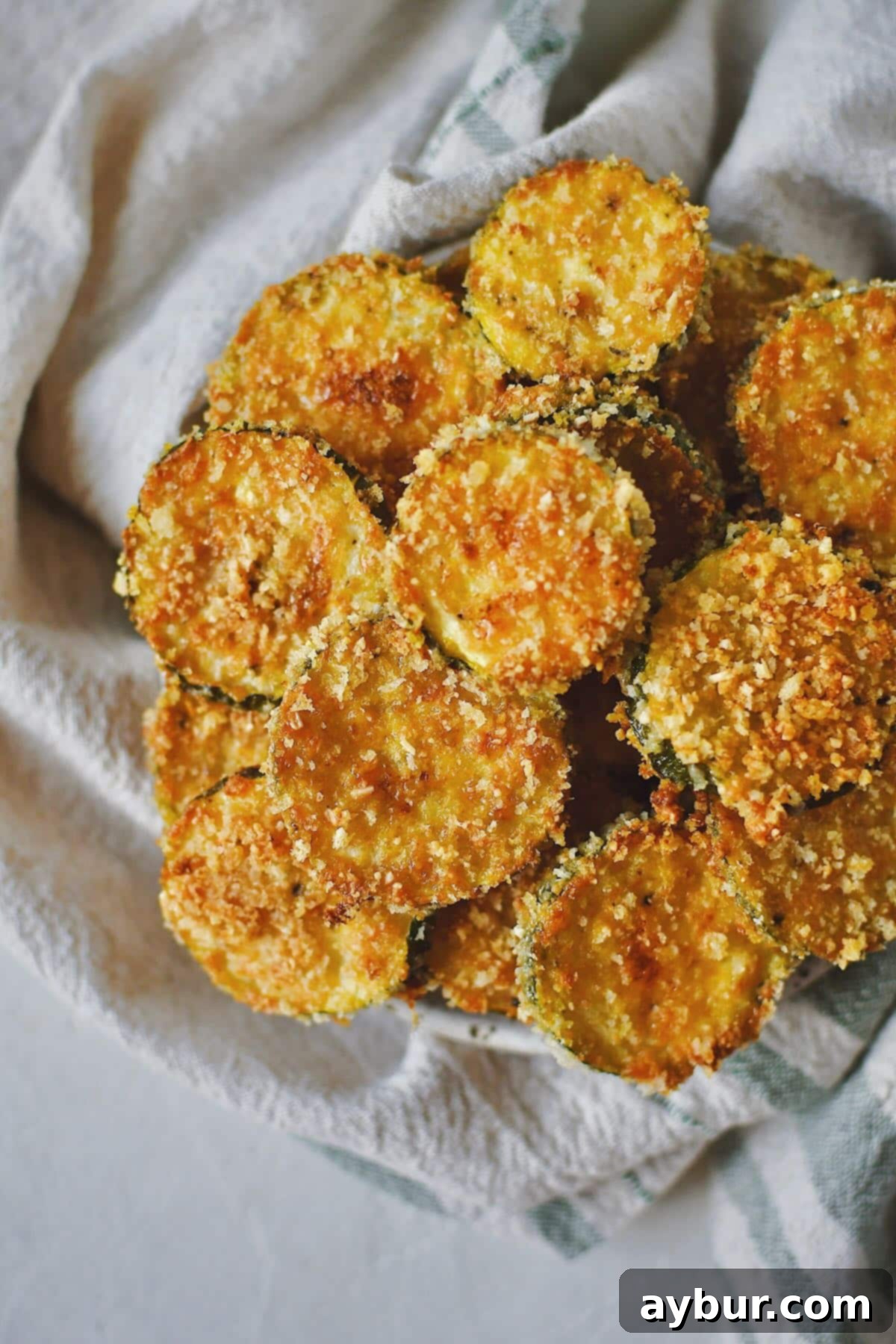 Baked Zucchini Crisps 11 A tantalizing stack of freshly baked, crispy Zucchini Chips on a plate, ready to be enjoyed as a snack or side.