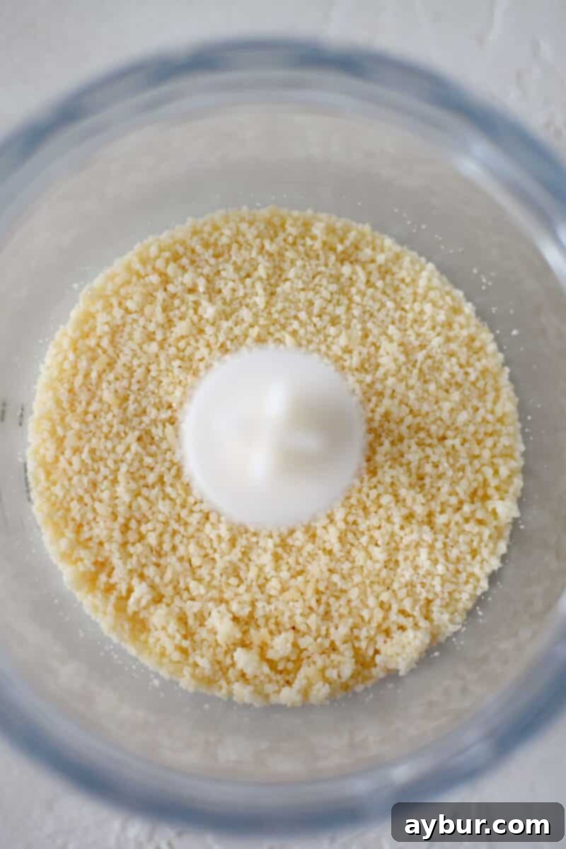 Baked Zucchini Crisps 6 Fresh Parmesan cheese being finely grated in a mini food processor, achieving a breadcrumb-like consistency for the coating.