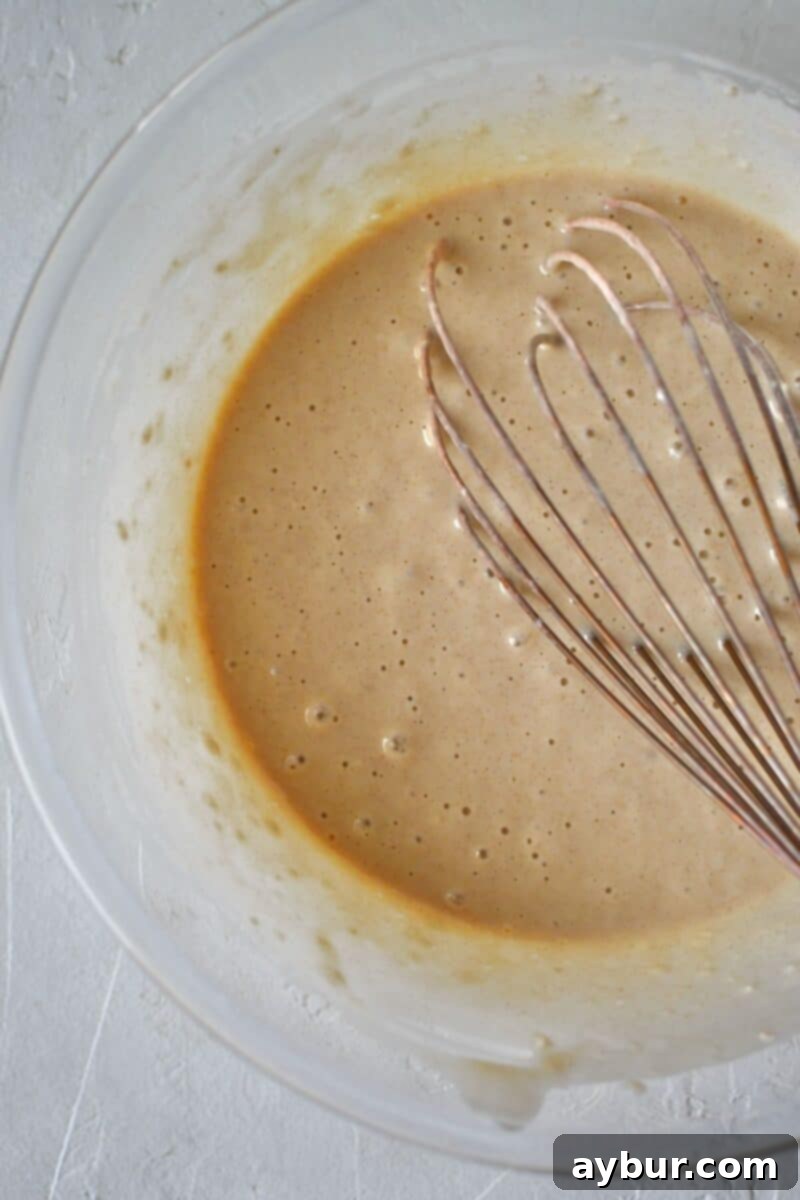 Warm Spiced Apple Pancakes 5 The fully mixed pancake batter, showing a smooth but slightly lumpy consistency, resting in a bowl and ready for cooking on a hot griddle.