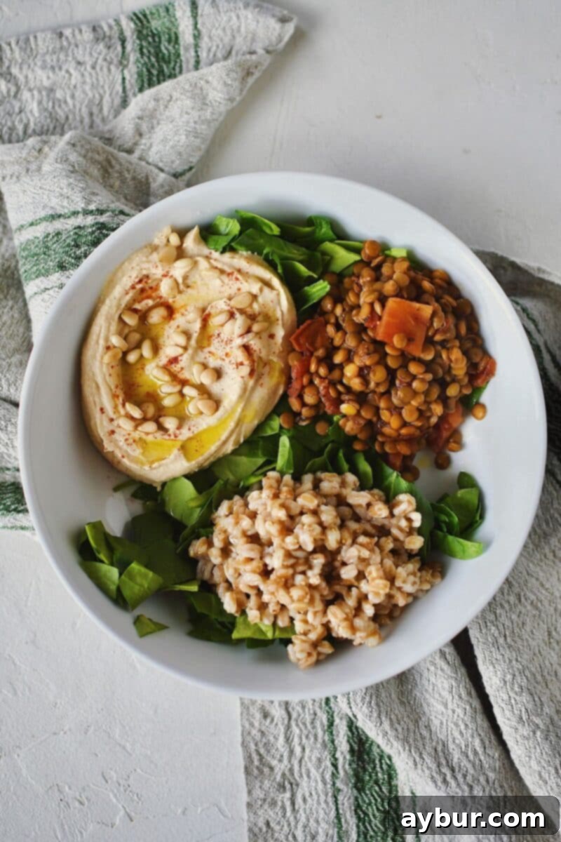 Adding cooked farro, an ancient grain, and tender green lentils to the base of the Mediterranean Bowl.
