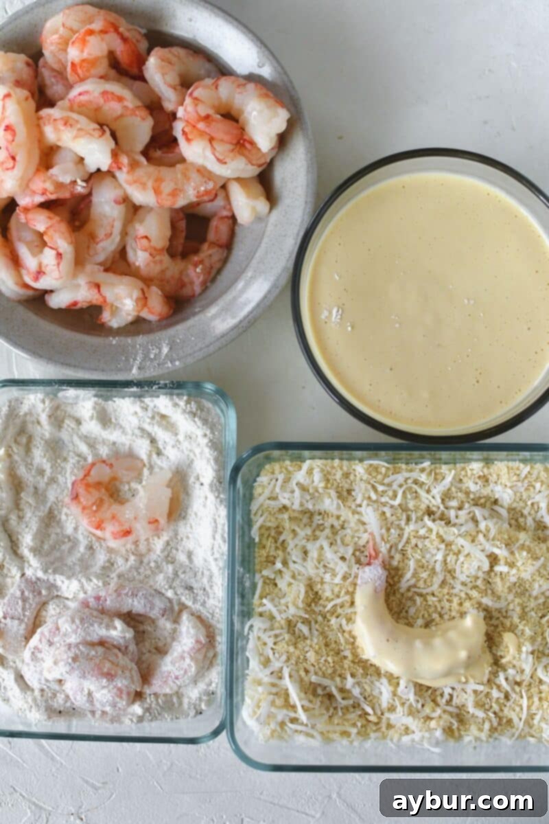 Demonstration of the breading process: dusting shrimp in seasoned flour, dipping into the wet batter, and finally coating thoroughly in the coconut panko mixture.
