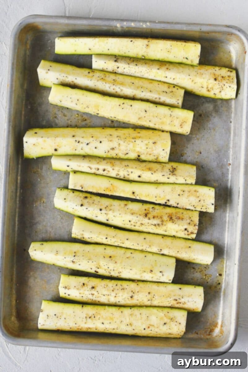 Seasoned zucchini spears, perfectly coated in oil and spices, ready for the hot grill.