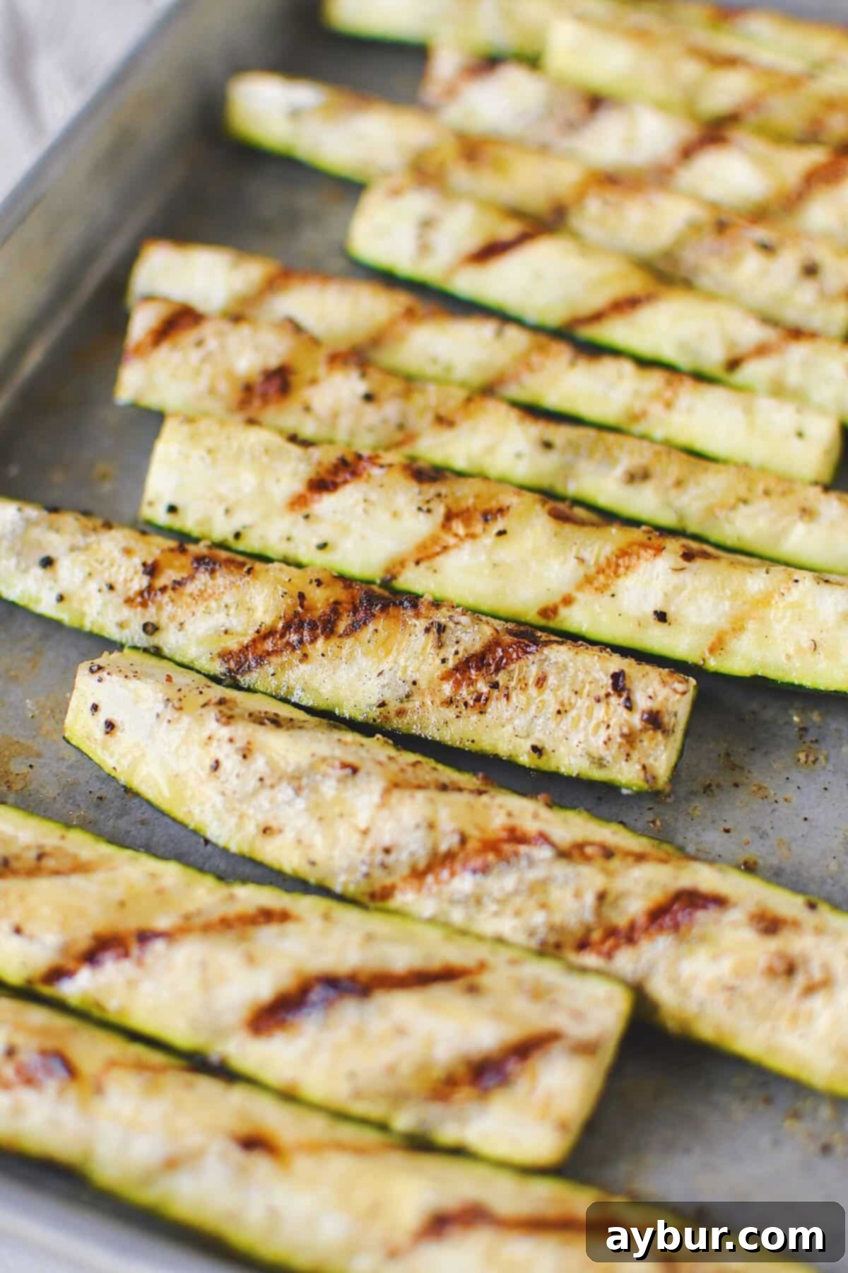 A generous serving of grilled zucchini, showcasing perfect char and tender texture.