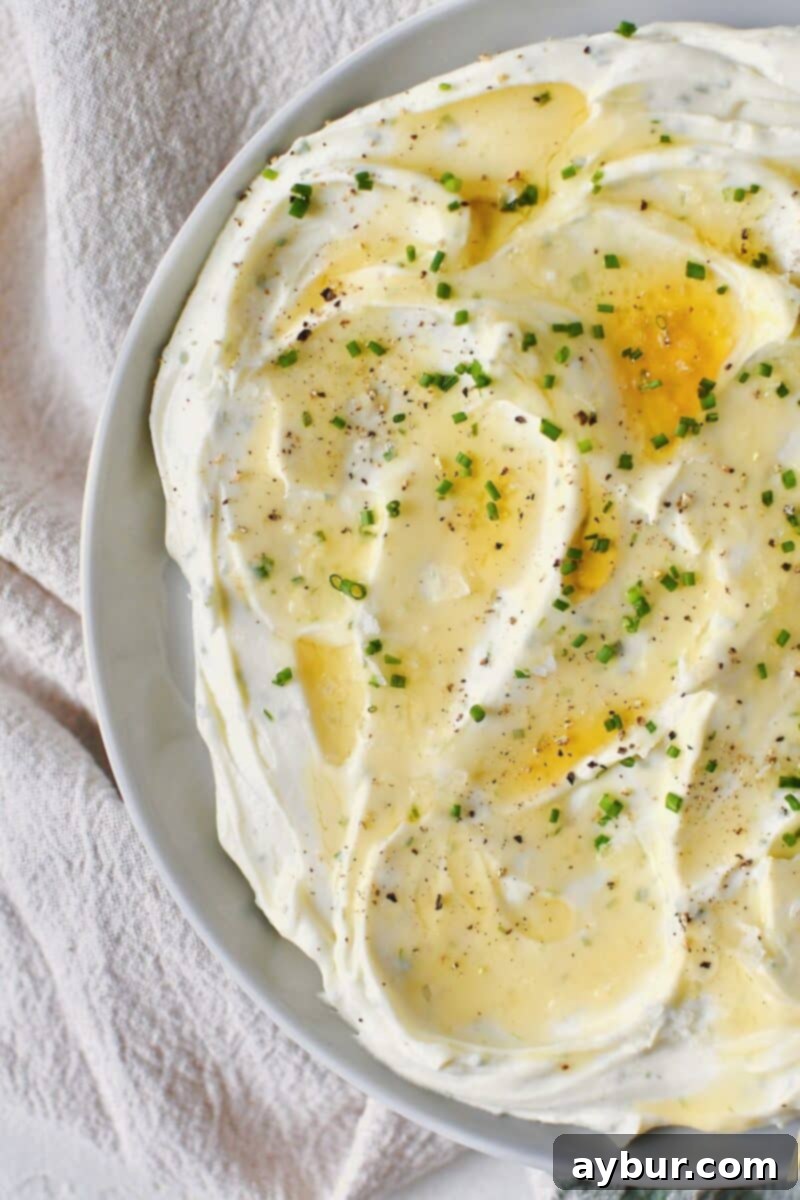 Velvet Goat Cheese Spread 6 Whipped Goat Cheese spread on a plate and topped with lavender honey, chives, and sea salt.