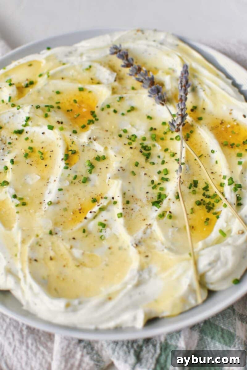 Velvet Goat Cheese Spread 7 Whipped Goat Cheese spread on a plate and topped with lavender honey, chives, and sea salt.