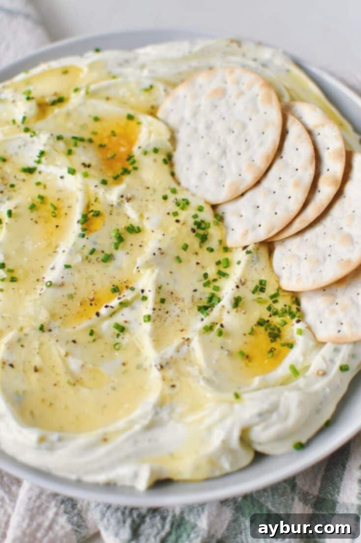 Velvet Goat Cheese Spread 10 Whipped Goat Cheese spread on a plate and topped with lavender honey, chives, and sea salt. Crackers laid on top for dipping.
