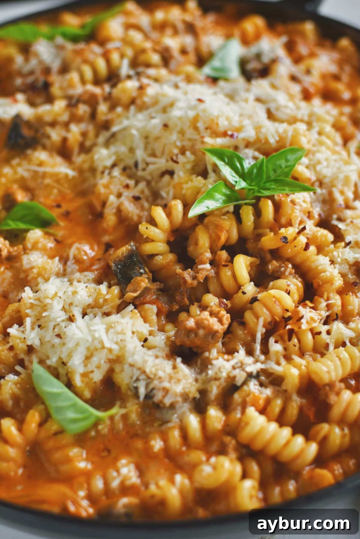 Italian Sausage Pasta finished in the pan and topped with extra parmesan and basil.