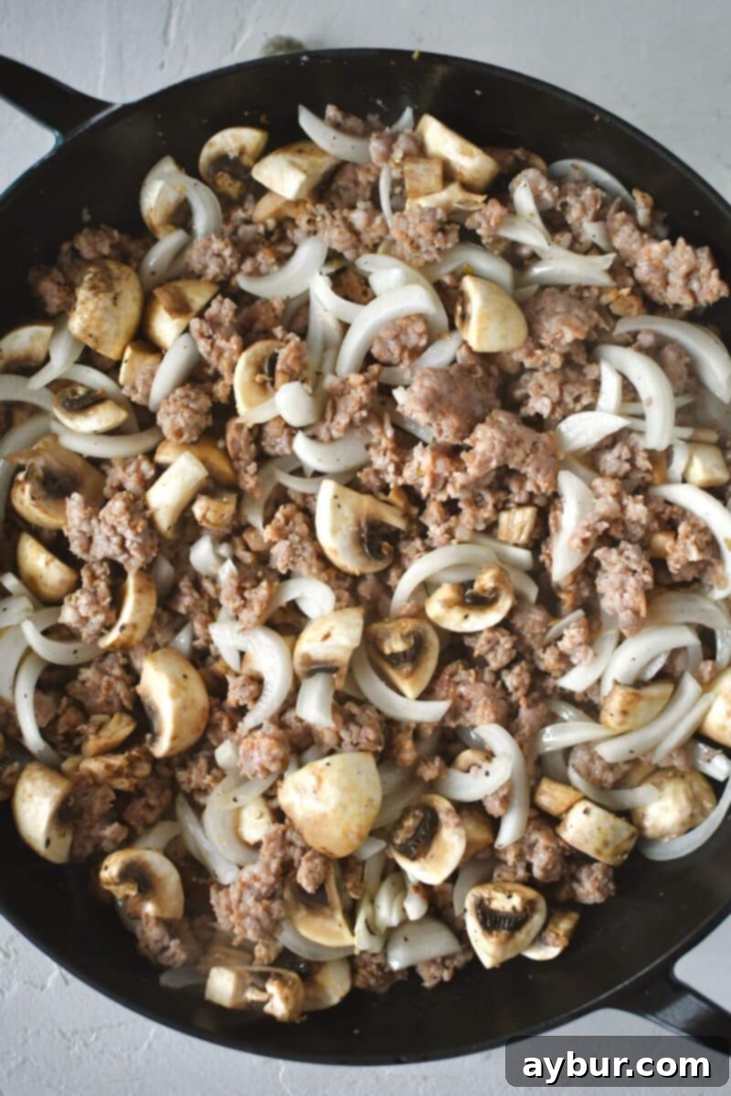 Diced button mushrooms and sliced onions stirred into browned italian sausage.