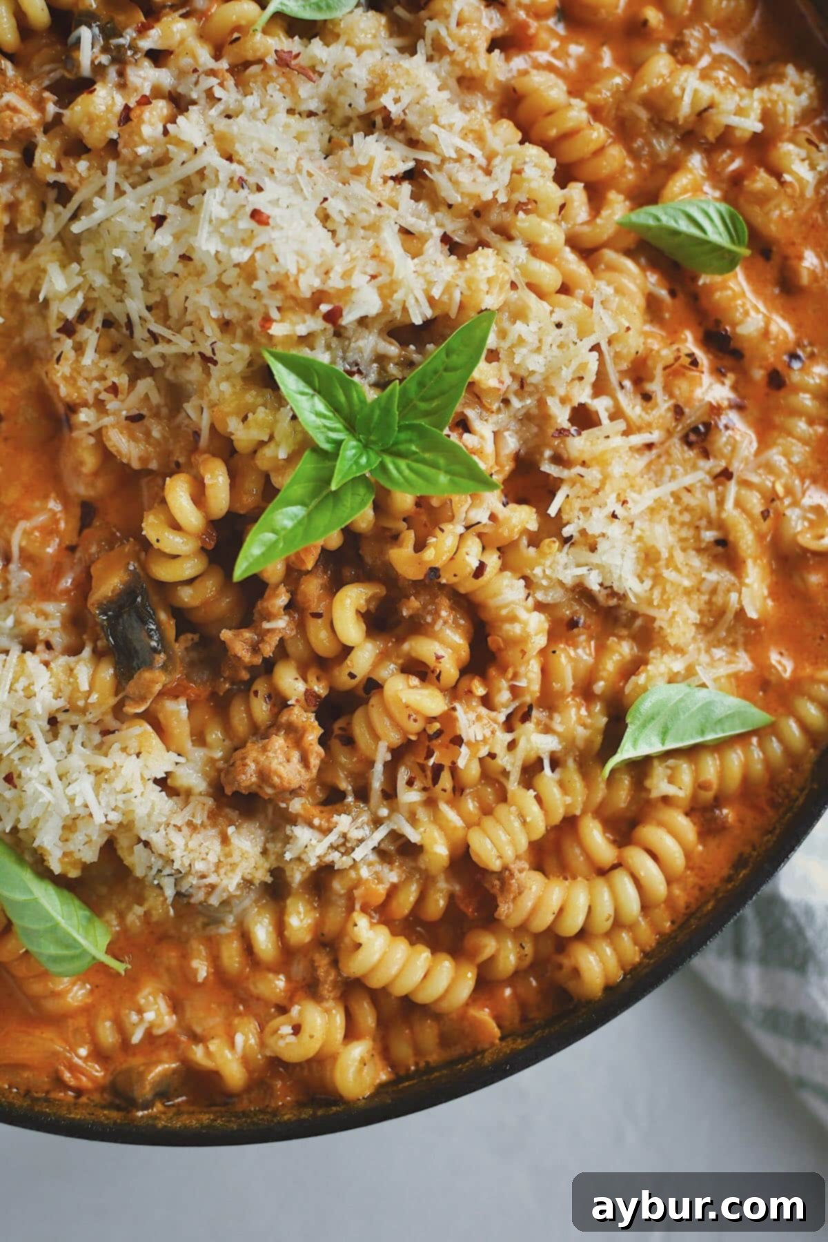 Italian Sausage Pasta finished in the pan and topped with extra parmesan and basil.