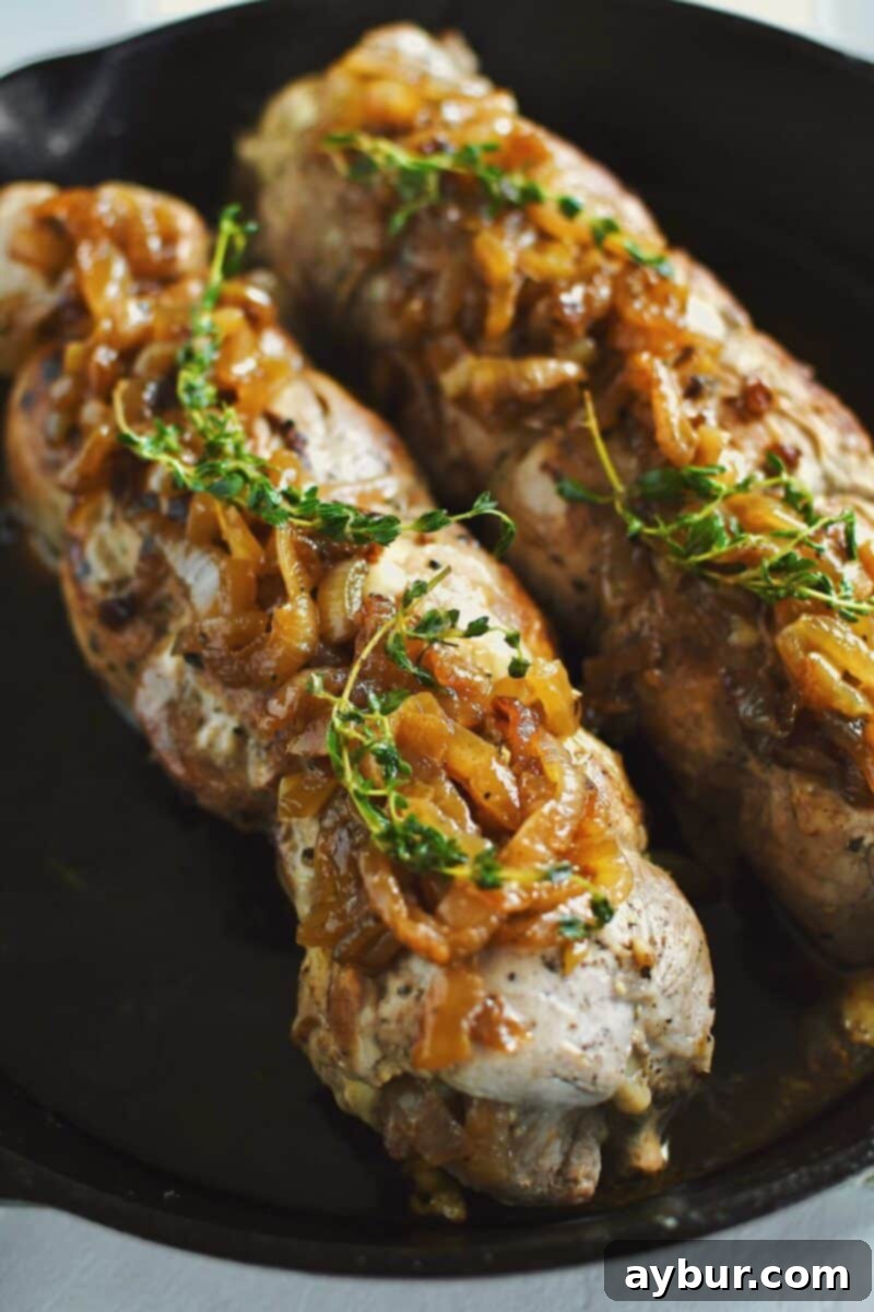 Savory Stuffed Pork Tenderloin 16 Beautifully seared and rested Stuffed Pork Tenderloins, topped with additional caramelized onions and fresh thyme, ready for carving.