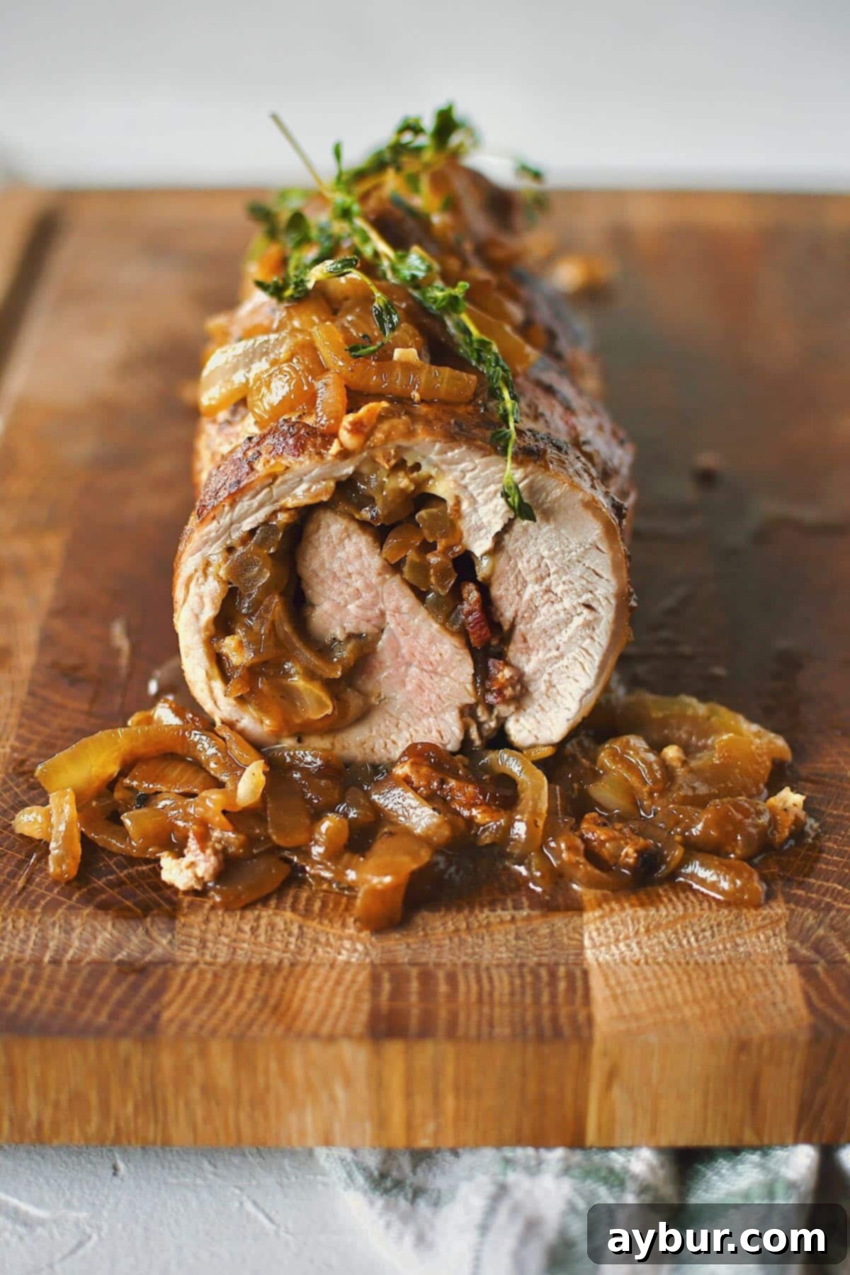 Savory Stuffed Pork Tenderloin 19 Close-up of perfectly sliced Stuffed Pork Tenderloin, showcasing the rich filling of caramelized onions, bacon, and melted Gruyère cheese.