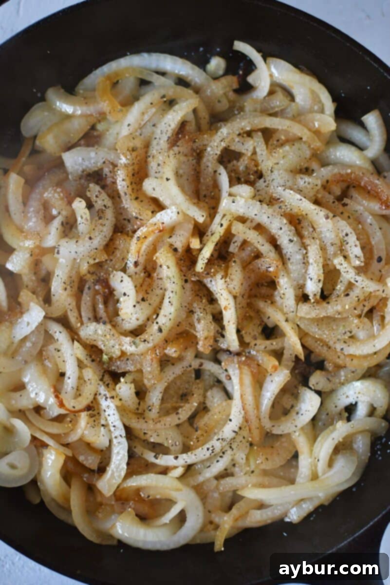 Savory Stuffed Pork Tenderloin 6 Onions softening and beginning to brown in a skillet, being deglazed with white wine to enhance flavor.