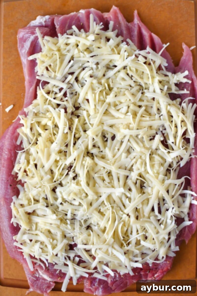 Savory Stuffed Pork Tenderloin 10 Shredded Gruyère cheese layered on a butterflied pork tenderloin, the first step of the stuffing process.