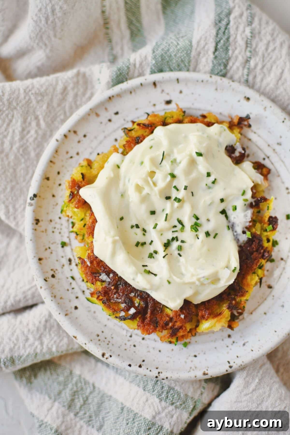 Zucchini Fritter topped with whipped goat cheese and ready to enjoy.