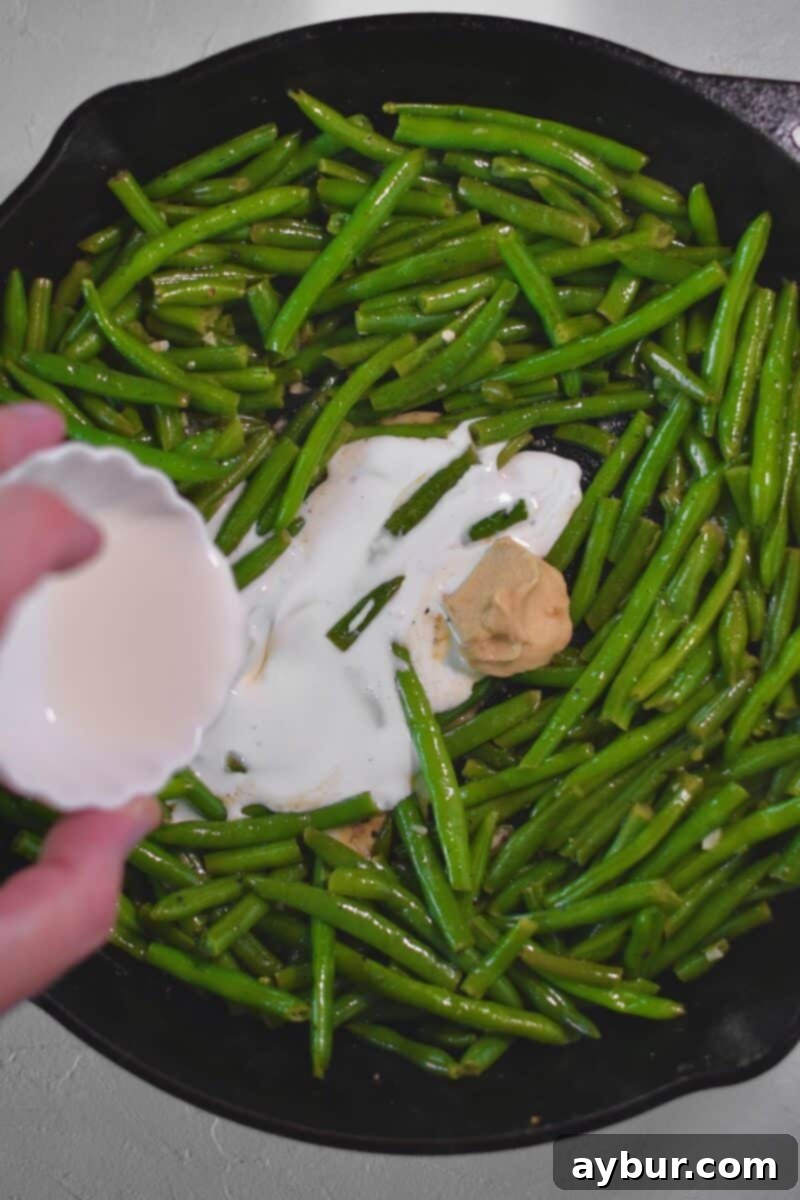 Creamy Green Beans 7 Adding dijon and cream to the pan to cream the green beans.