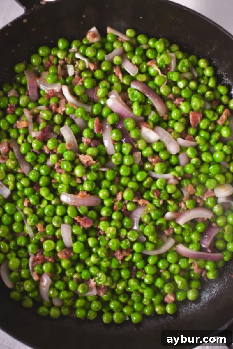 Pea Salad 5 Diced red onion and store-bought bacon bits cooking alongside the peas in a skillet, adding savory and aromatic layers.
