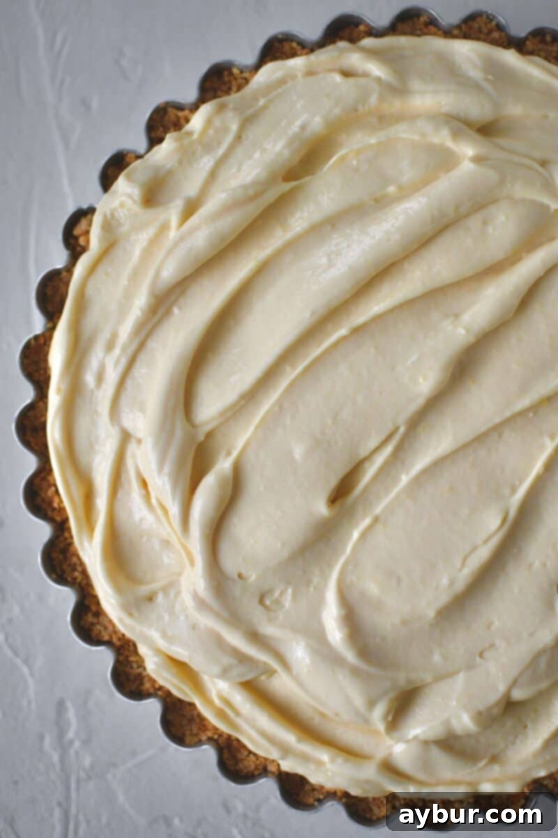 Creamy Banana Dream Pie 11 The remaining pie filling being spread gently over the banana layer, completely covering the fruit and creating a smooth, enticing top for the pie.