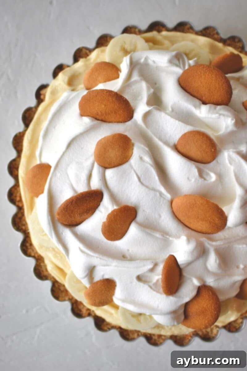 The fully garnished Banana Pudding Pie, with fresh bananas, whipped cream, and crumbled Nilla wafers, ready for serving.