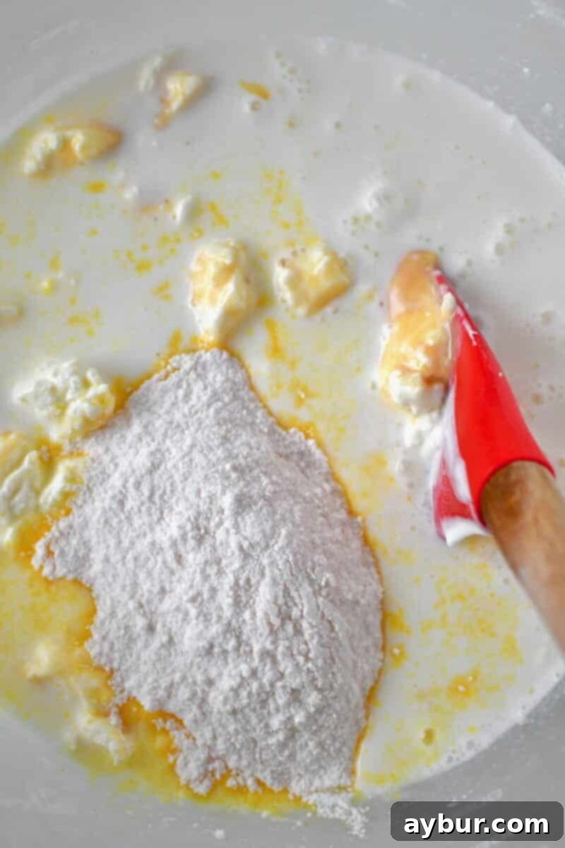 Creamy Banana Dream Pie 8 Various milks (whole milk, sweetened condensed milk) and instant pudding mix being added to the whipped cream cheese in a stand mixer to create the luscious pie filling.