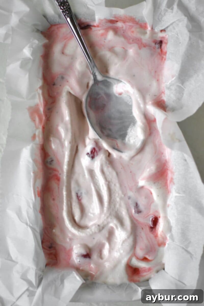 Strawberry Delight 14 The beautiful blend of creamy churned ice cream and strawberry swirl, thoroughly mixed in a freezer-safe storage dish, ready for final hardening.