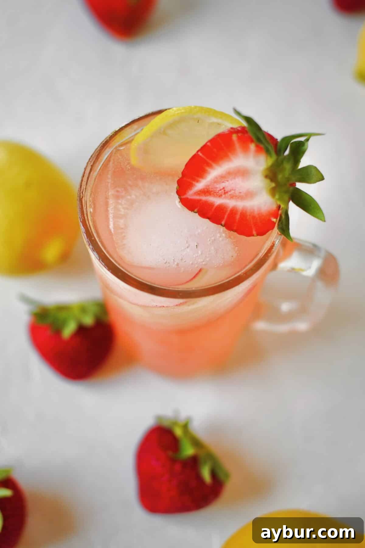 Sweet Strawberry Lemonade 10 Top view looking into a glass of Strawberry Lemonade, garnished with a rhubarb curl and lemon slice.