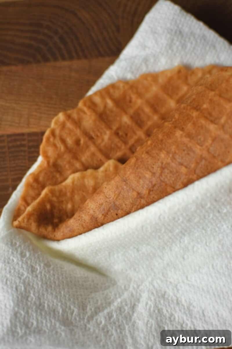 Crispy Homemade Waffle Cones 11 Rolling up a waffle cone, ensuring that I get a fold in the plyable waffle so there is no hole in the bottom.