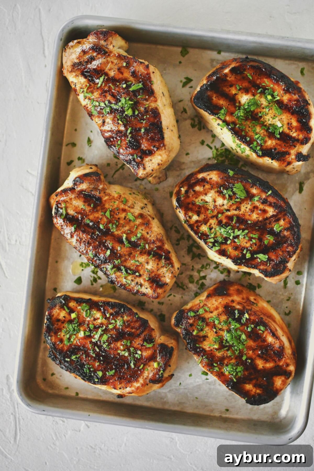 Perfectly Brined Pork Chops, golden brown and juicy, fresh off the grill and ready to be served.