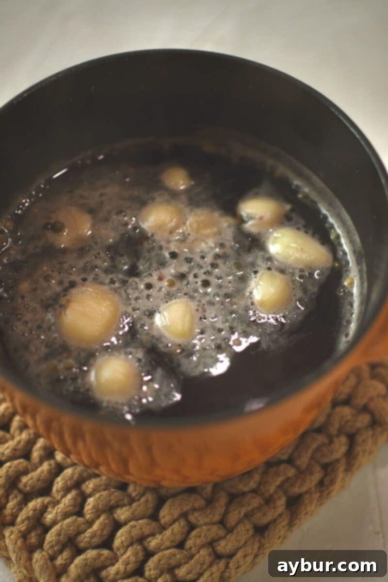 All brine ingredients, except the ice, simmering gently in a small pot on the stove, warming until the salt and sugar melt and the liquid clarifies.