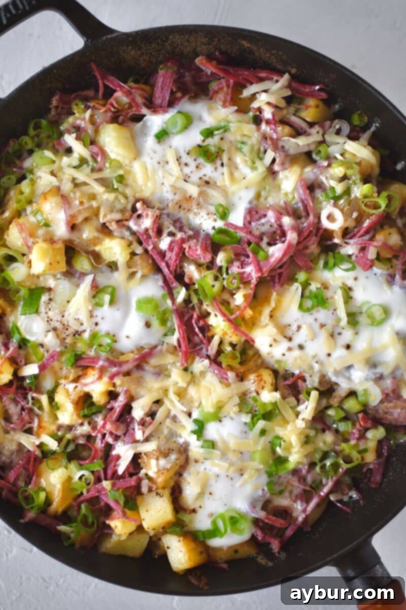 Fresh eggs are carefully cracked into created wells within the cheesy corned beef hash, then cooked under a lid until the whites are perfectly set, promising a rich, runny yolk.