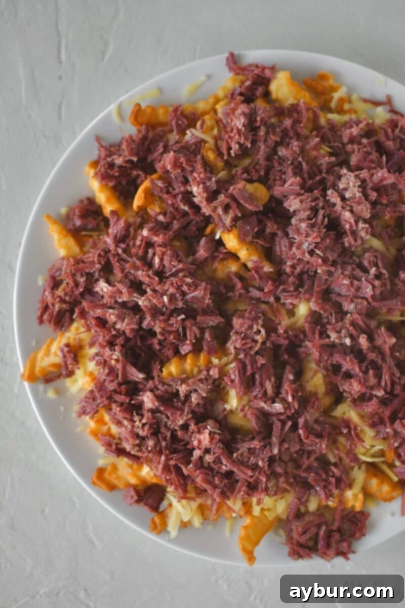 Irish Nachos 5 Layering warm shredded corned beef on Irish cheddar over crispy crinkle french fries.