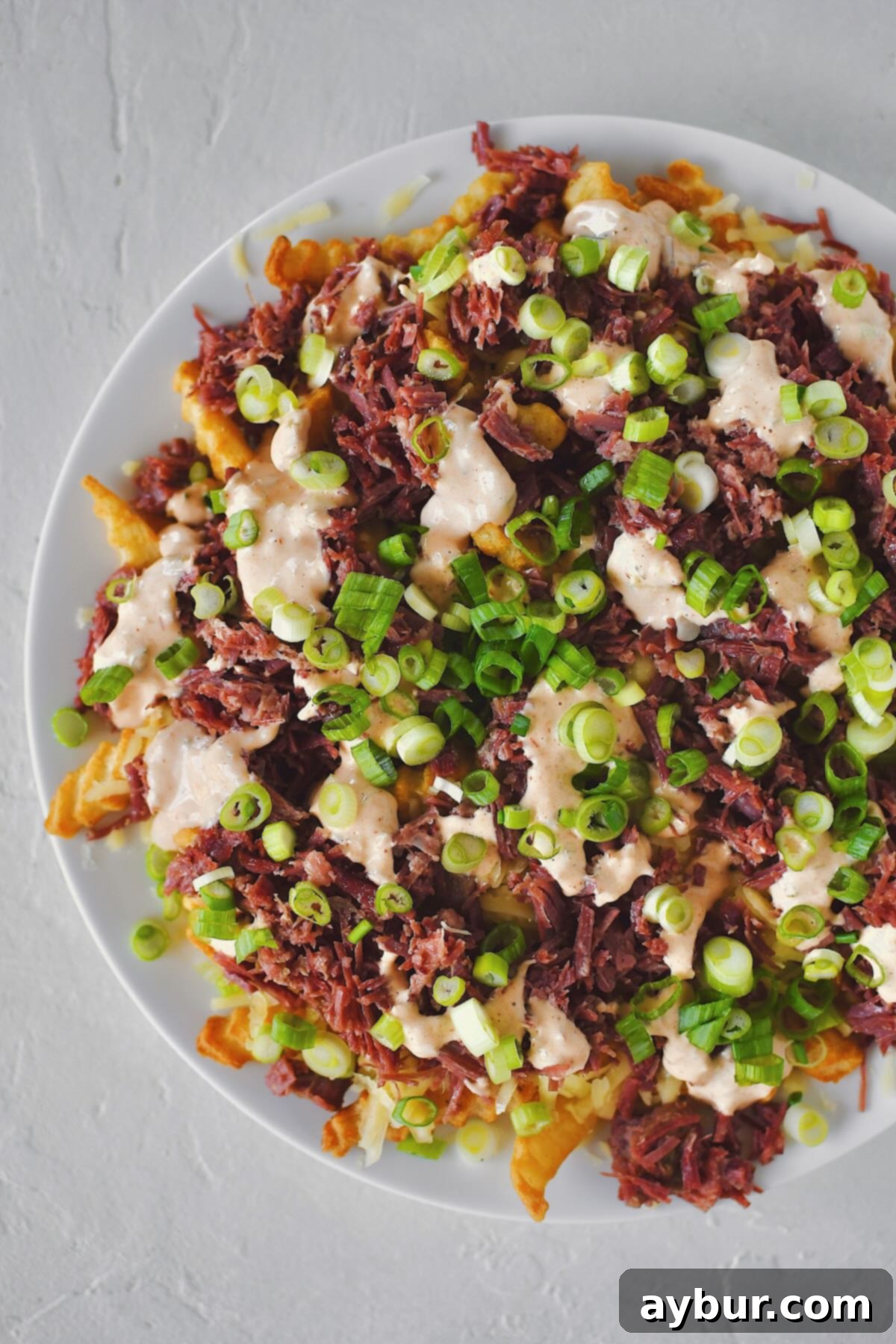 Irish Nachos 6 Finished Irish Nachos with white cheddar, corned beef, remoulade, and green onions on top of crispy crinkle french fries.