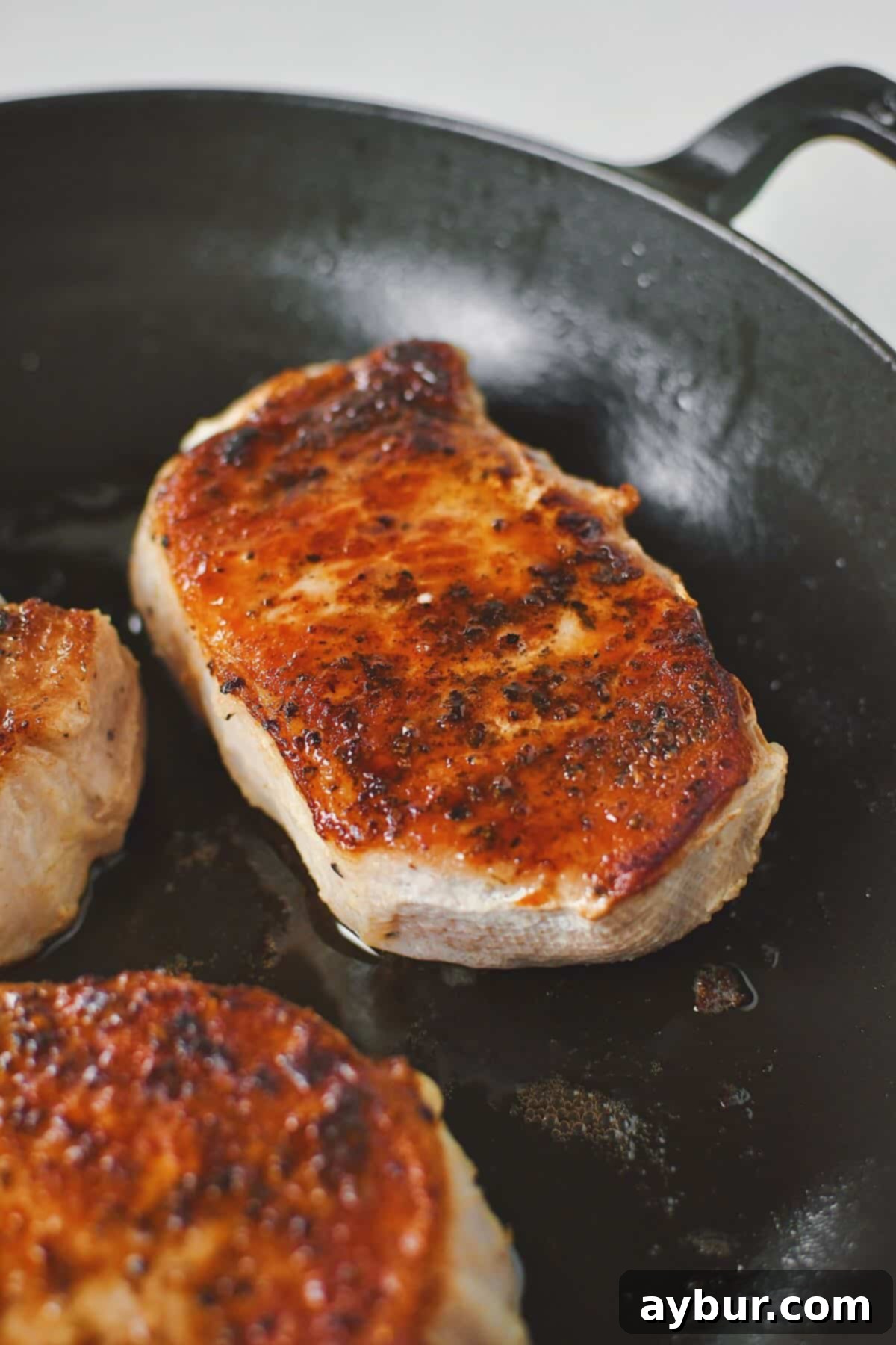 Perfectly Tender Sous Vide Pork Chops 2 Olive oil warmed in a skillet, and searing the sous vide pork chops until crisp and dark brown on both sides.