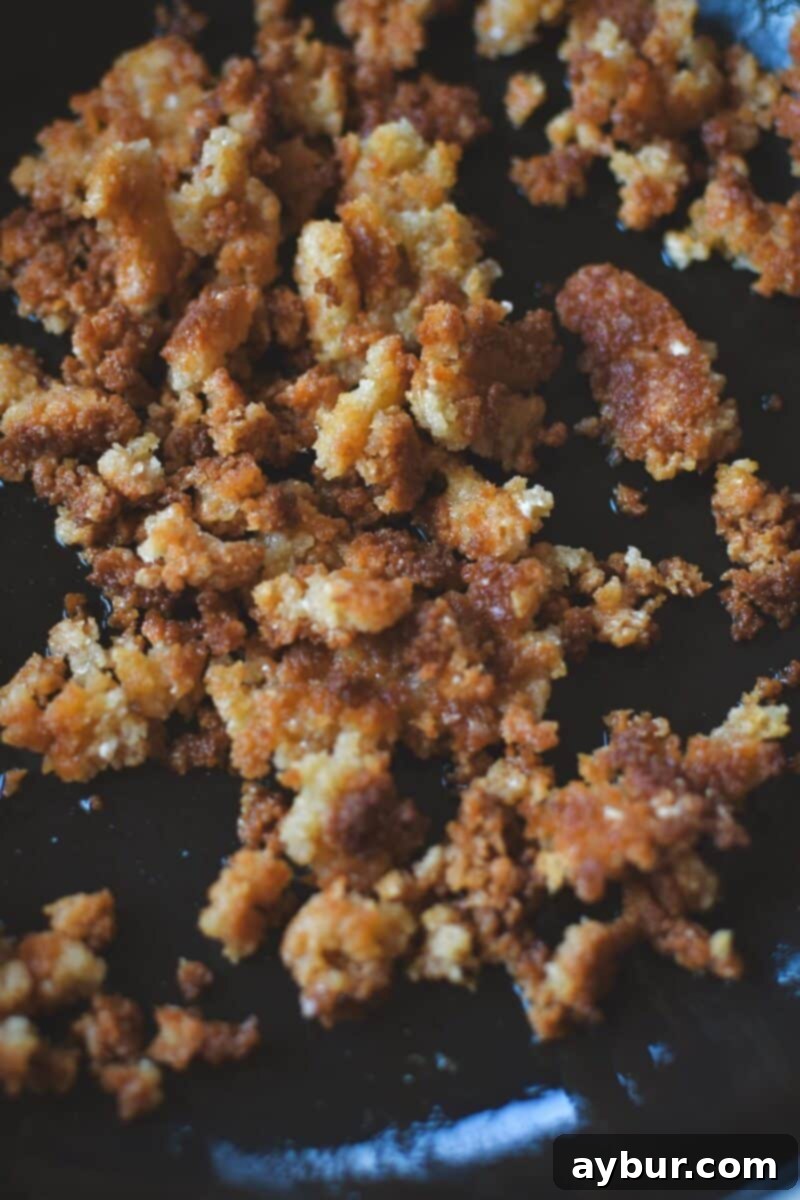 Toasting panko bread crumbs and finely grated parmesan cheese in a skillet over low heat until golden brown and crispy.