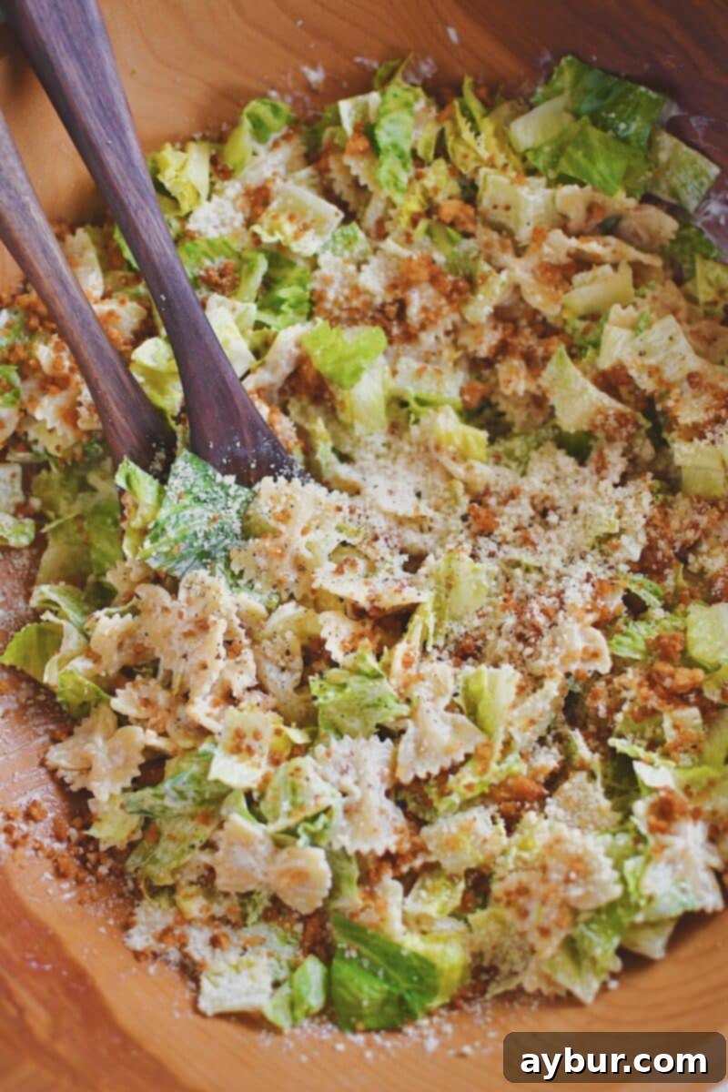 A large bowl filled with Caesar Pasta Salad, showing the tossed pasta, lettuce, and crispy crumbs, ready for serving.