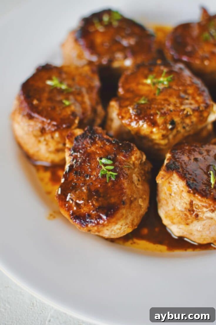 Pork Tenderloin Medallions basted with sauce and resting on a plate ready to eat.