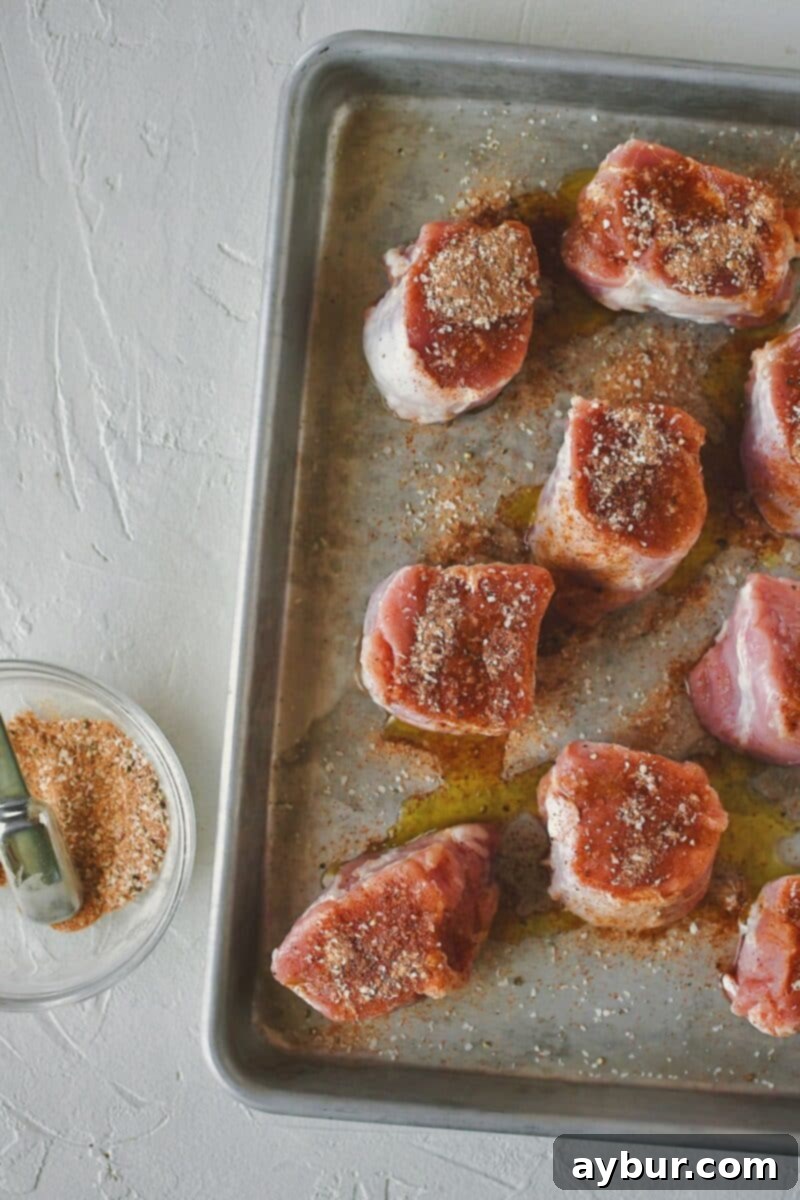 Seasoning the pork tenderloin medallions with a blend of salt, pepper, paprika, and roasted garlic powder for maximum flavor.
